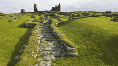 Historische Ruinen von Jarlshof inmitten grüner Hügel in Schottland.