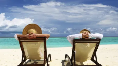 Entspanntes Paar sitzt auf Liegestühlen am tropischen Strand.