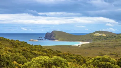 Türkisblaues Meer trifft auf grüne Hügel in Tasmanien.