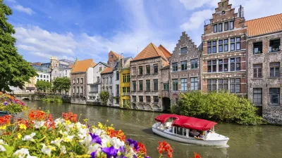 Buntes Stadtbild mit Kanälen und einem roten Boot in Gent, Belgien