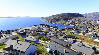 Bunte Häuser in der grönländischen Stadt Qaqortoq mit Blick auf das Meer.