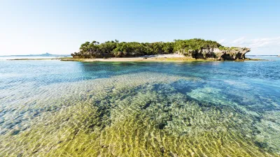 Tropische Insel mit klarem Wasser und felsiger Küste.