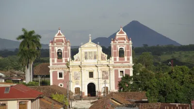 Historische Kirche mit rosa Fassade vor vulkanischer Landschaft