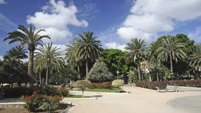 Ein Park mit Palmen und blühenden Pflanzen lädt zur Entspannung ein.