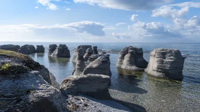 Felsformationen stehen im flachen Wasser am Ufer des Meeres.