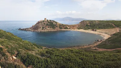 Sardinischer Strand mit felsiger Küste und türkisfarbenem Wasser.