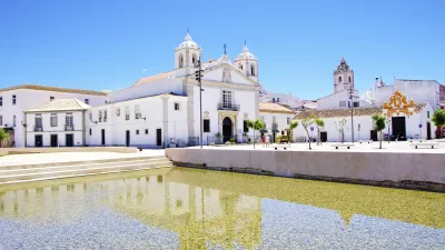 Historische Kirche mit weißer Fassade spiegelt sich im Wasser