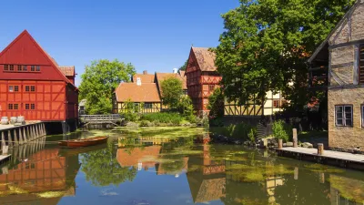 Historische Fachwerkhäuser spiegeln sich im ruhigen Wasserkanal.