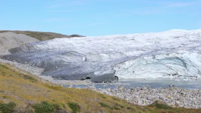 Ein Gletscher erstreckt sich über eine felsige Landschaft in Grönland.