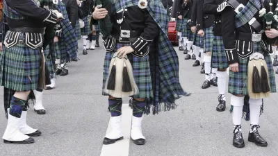 Schottische Musiker in traditioneller Kleidung spielen auf der Straße.