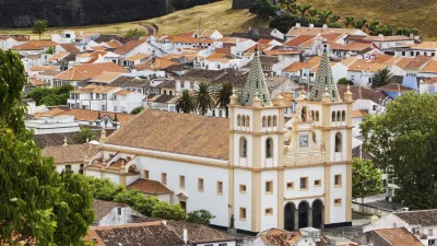 Weiße Kathedrale mit zwei Türmen dominiert die Stadtlandschaft.