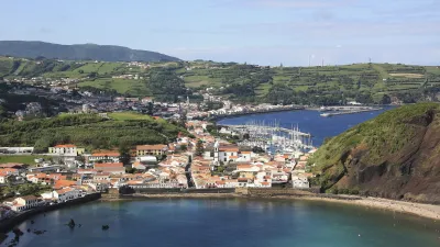 Blick auf die Hafenstadt Horta auf den Azoren mit weißen Häusern und blauem Wasser.