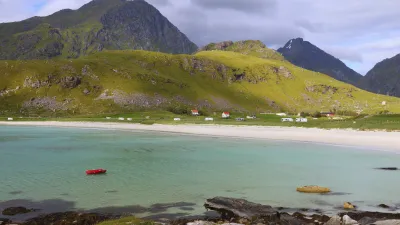 Strandlandschaft mit Bergen und Häusern in den Lofoten, Norwegen