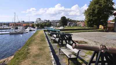 Historische Kanonen stehen am Ufer eines Hafens in Norwegen.