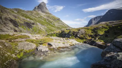 Trollwand in Norwegen mit blauem Fluss im Vordergrund