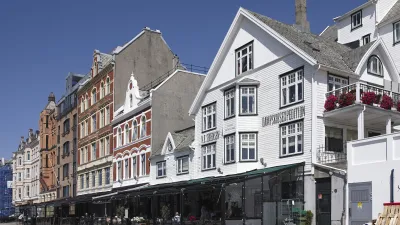 Reihen von bunten Häusern säumen eine belebte Stadtstraße.