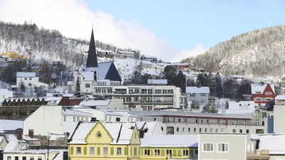 Schneebedeckte Häuser und eine Kirche prägen das Stadtbild von Harstad.