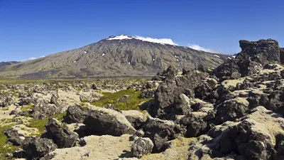 Vulkan Snaefellsjökull erhebt sich über felsiger Landschaft.