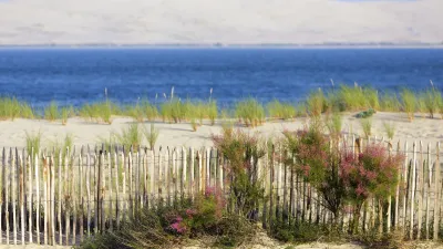 Zaun auf Dünenlandschaft mit Blick auf das Meer