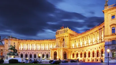 Wien Hofburg bei Nacht mit beleuchteter Fassade und Denkmal.