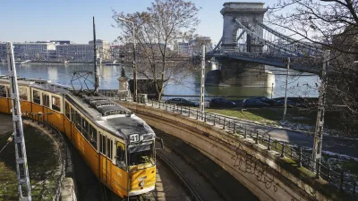 Gelbe Straßenbahn fährt an der Donau in Budapest vorbei