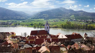 Dürnstein mit seinen roten Dächern und dem Kirchturm am Ufer der Donau.