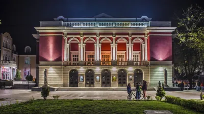 Erleuchtetes Opernhaus in Rousse bei Nacht mit Menschen im Vordergrund