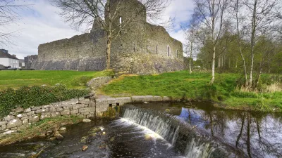 Historische Burgruine mit Wasserfall im grünen Irland.