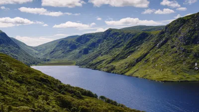 Irlands malerischer See eingebettet zwischen grünen Hügeln und Bergen.