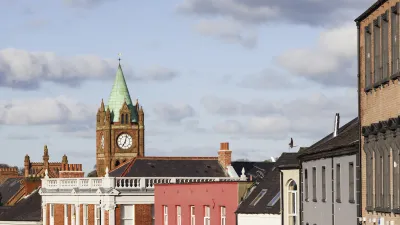 Historische Häuser mit einem Uhrturm im Hintergrund