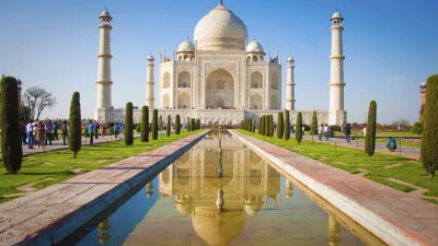 Der Taj Mahal spiegelt sich im Wasser des Vorhofs