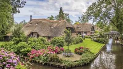 Traditionelles Bauernhaus mit blühendem Garten am Kanal in Giethoorn