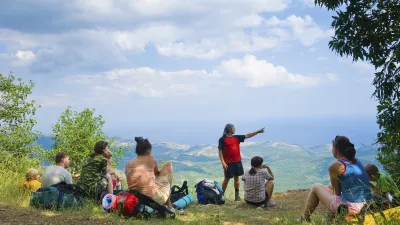 Wandergruppe macht eine Pause mit Blick auf die Landschaft