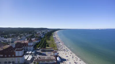 Sonnenbather und Gebäude säumen die Promenade von Binz auf Rügen.