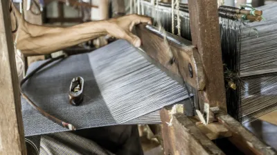 Indischer Weber arbeitet an einem traditionellen Webstuhl.