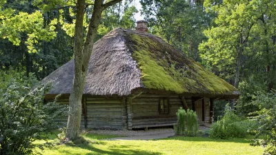 Traditionelles lettisches Holzhaus mit Strohdach im Freilichtmuseum.