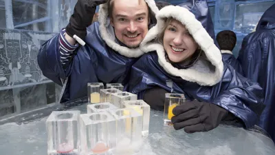 Lachendes Paar genießt Cocktails in einer Eisbar.