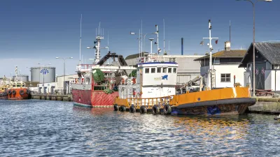 Rote und orange Fischerboote liegen im Hafen von Skagen.