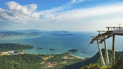 Seilbahn überblickt grüne Hügel und das türkisfarbene Meer.