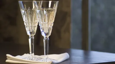 Zwei Champagnergläser stehen auf einem Tisch mit weißem Tuch.