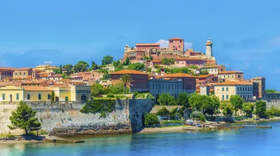 Historische Gebäude erstrecken sich am Hang über dem Hafen von Portoferraio.