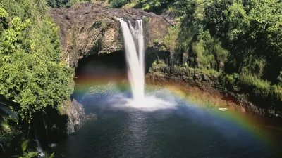 Ein Wasserfall stürzt in einen Teich und erzeugt einen wunderschönen Regenbogen.