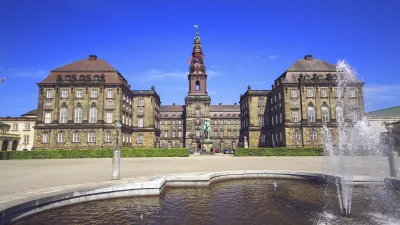 Blick über einen Springbrunnen auf den Christiansborg Slot in Kopenhagen.