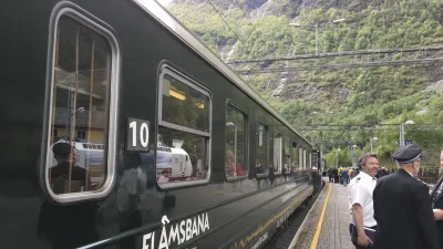 Grüner Zug der Flåmsbahn steht am Bahnsteig in Norwegen