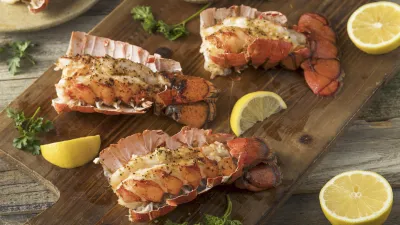 Gebratener Hummer mit Zitrone und Kräutern auf Holzbrett