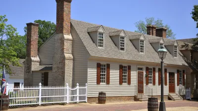 Koloniales Haus mit weißen Fensterläden und Ziegelkamin.