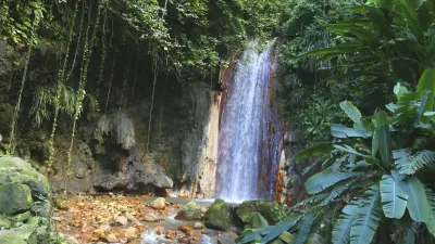 Ein Wasserfall stürzt über Felsen in einen kleinen Fluss.
