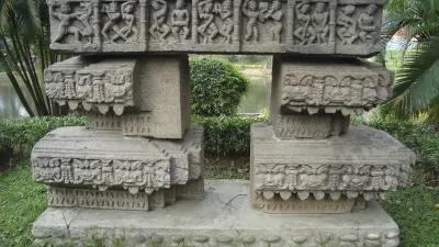 Historische Steinsäulen mit Reliefs stehen im Park.