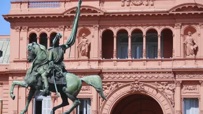 Eine Reiterstatue steht vor dem rosafarbenen Regierungsgebäude Casa Rosada in Buenos Aires.