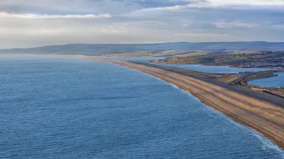 Chesil Beach, eine lange Sandbank, erstreckt sich entlang der Küste.